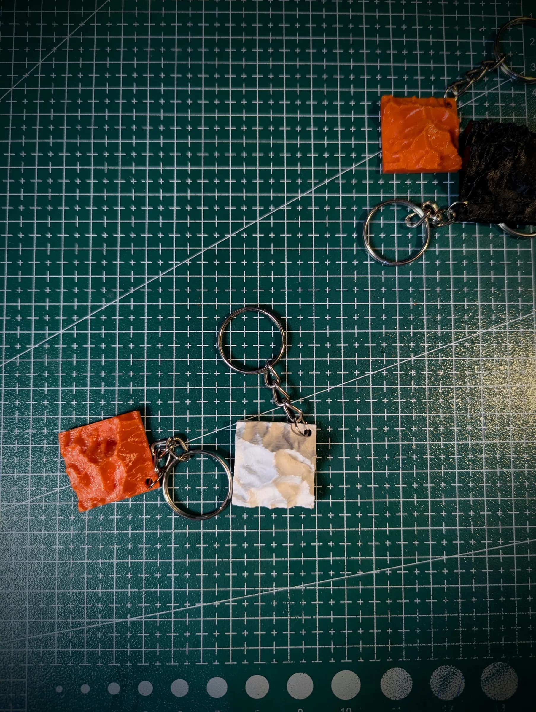 Terrain keychains laid out on the studio cutting mat